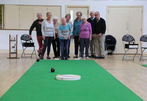Carpet Bowls Club Eco Hub picture of A group of 9 happy people playing carpet bowls