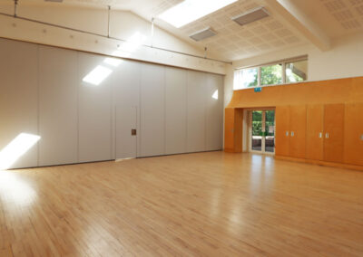The Ellis Hall - the larger section of the main hall with high ceiling and sky lights a wooden floor and door to the outside community area